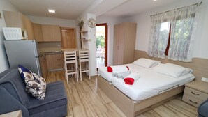 Une chambre à coucher de taille modeste, comprenant un lit, des tables de chevet et un petit espace bureau.