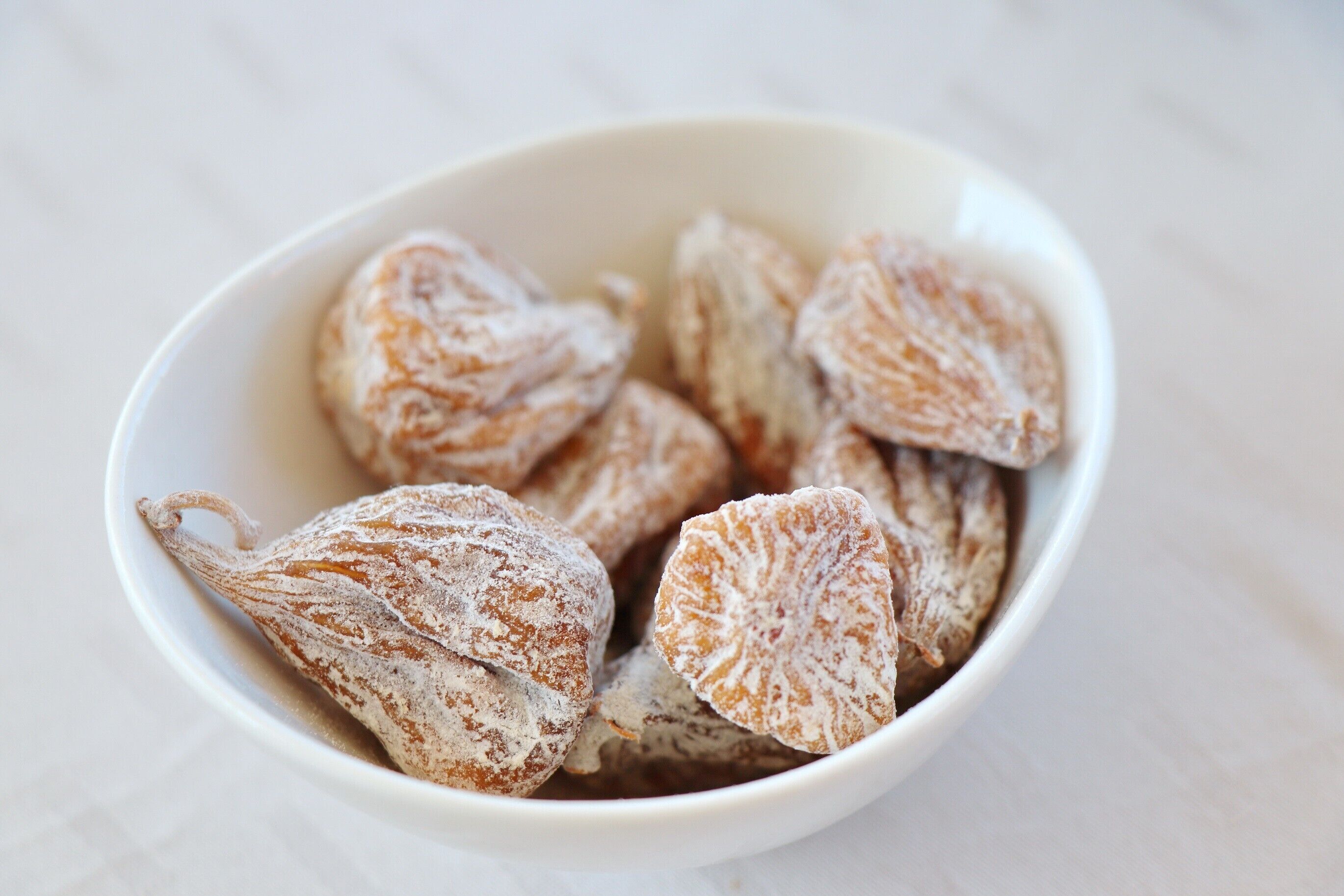 A bowl of pastries dusted with powdered sugar.
