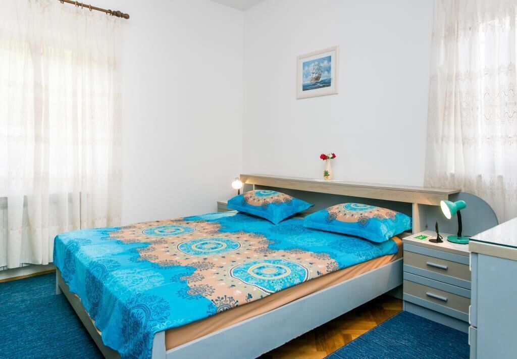 Une chambre à coucher comprenant un lit, une table de chevet, un bureau et une chaise.
