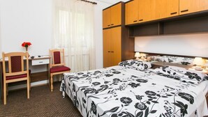 Een slaapkamer met een bed, een bureau en stoelen.