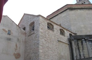 A stone building with arched windows and a large door.