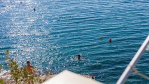 A view of a beach with people swimming and standing on the shore. - Apartments Nena (ST) - One Bedroom Apartment with Terrace and Sea View (Pisak)