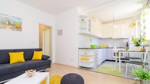 A modern apartment with a living area, kitchenette, and dining space.