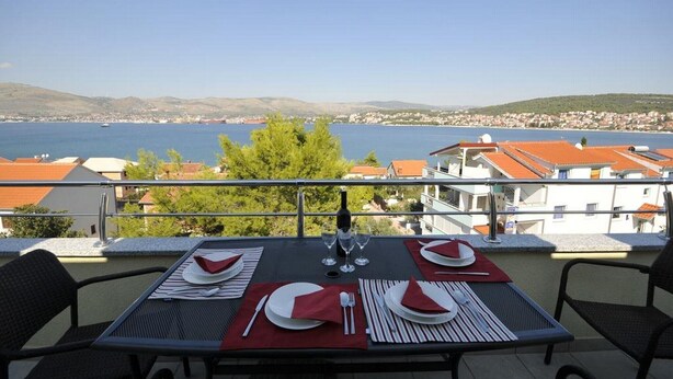 Una mesa para dos con vista al mar y un pueblo al fondo.