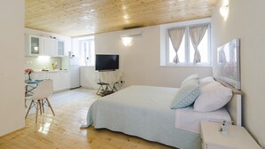Ein Schlafzimmer mit Bett, Nachttisch und Fernseher.