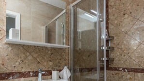 A modern bathroom with a glass-enclosed shower, a white sink, and a marble-tiled wall. - Room Primi - Double Room with Terrace (Dubrovnik)