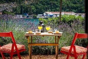 A table set outdoors with a view of a body of water and greenery in the background. - Captain's Studio - Studio with Terrace (Mokosica)