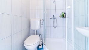 A modern bathroom with a toilet, shower, and sink. - Rooms Katja & Lara - Twin Room (Dubrovnik)