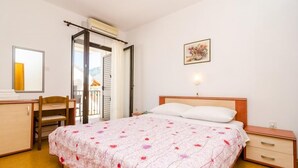 Ein Schlafzimmer mit Bett, Schreibtisch, Stuhl und Nachttisch.