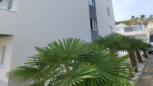 Ein modernes Gebäude mit weißer Fassade und zahlreichen Fenstern.