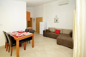 Cozy living space with a dining area and seating area, featuring a wooden table and comfortable sofa.