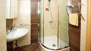 Une salle de bain moderne avec une douche à parois de verre, un lavabo blanc et un porte-serviettes.