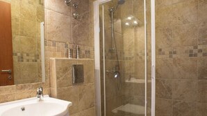 Ein Badezimmer mit Duschkabine, Waschbecken und Toilette.