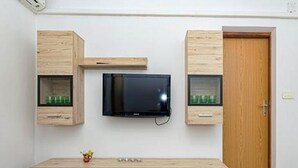 A room with a wooden cabinet, a television, and a wooden door. - Apartments Radojković Lumbarda -One Bedroom Apartment with Terrace and Partial Sea View(A1) (Lumbarda)