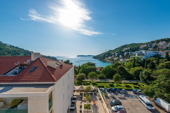 A coastal hotel with a rooftop terrace, parking area, and views of the sea and surrounding hills. - Apartments Arla Exclusive - Superior Studio Apartment with Balcony (Dubrovnik)