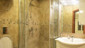 A bathroom with a glass-enclosed shower, a toilet, and a sink with a mirror above it. - Milka & Miho Apartments - Double or Twin Room 1 (Second Floor) (Dubrovnik)