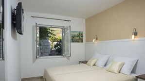 A bedroom with a bed, a TV mounted on the wall, a window with an open shutter, and a small picture on the wall. - Milka & Miho Apartments - Double or Twin Room 1 (Second Floor) (Dubrovnik)