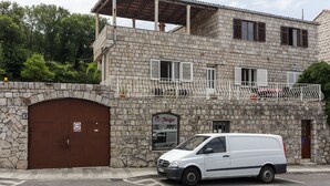 A stone building with a white van parked in front.