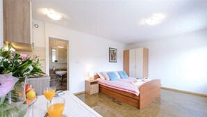 Ett sovrum med en säng, ett nattduksbord och en frukostuppsättning med frukt och dryck.