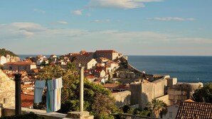 A coastal town with historic buildings, a fortified structure, and a view of the sea. - Apartments Cava Dubrovnik - Premium Studio with Patio and Sea View (Dubrovnik)