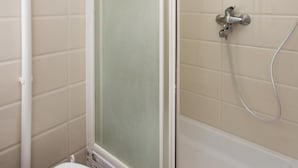 Ein Badezimmer mit Toilette, Duschkabine und Badewanne.