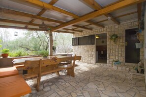 Relax in a serene outdoor space with a fireplace, dining area, and lush views.