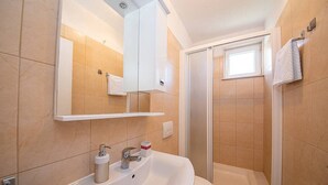 Un baño con lavamanos, inodoro y ducha.