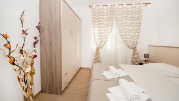 A hotel room with a bed, a wardrobe, and a decorative plant. - Guest House Mia  - Studio Apartment (Split)