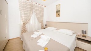 A hotel room with a bed, a bedside table, a lamp, and a window with curtains. - Guest House Mia  - Studio Apartment (Split)