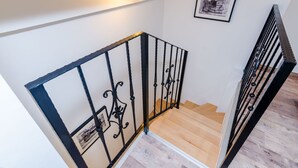 Un escalier avec des rampes en métal noir et des marches en bois.