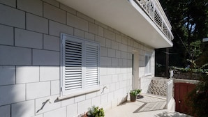 A building facade with white shutters, a tiled patio, and potted plants. - Guesthouse Matusic - Double Room (Dubrovnik)