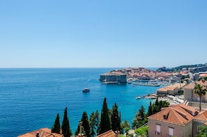 Une ville côtière dotée de bâtiments historiques, d’un port de plaisance et d’eaux d’un bleu cristallin.