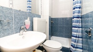 Une salle de bain avec un lavabo, des toilettes et une baignoire.