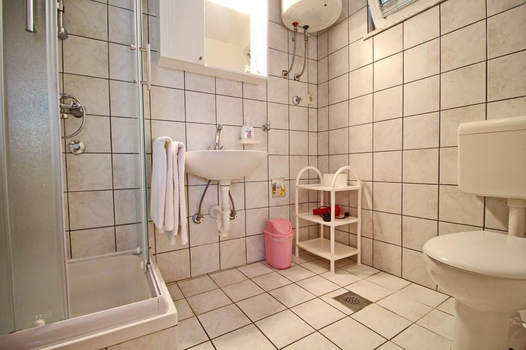 A bathroom with a shower, sink, and toilet.