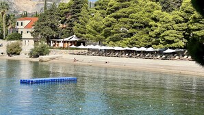 A waterfront hotel with outdoor seating and a pool.