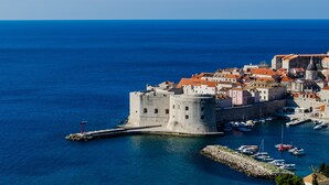A coastal town with a prominent castle, a marina with boats, and a clear blue sea. - Apartments Bonavista - Superior Two Bedroom Apartment with Balcony and Sea View (A1) (Dubrovnik)