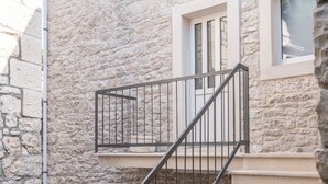 Eine Treppe mit beigen Stufen führt zu einer Empore mit einem Fenster.