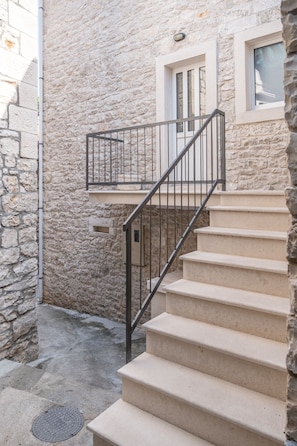 Un edificio in pietra con una scala che conduce a un balcone.