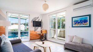 Ein modernes Wohnzimmer mit einer Couch, einem Couchtisch und einem an der Wand befestigten Fernseher.