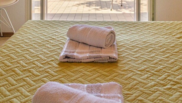 A room with a bed, a view of the sea, and a chair outside. - Rooms Sani - Double Room with Terrace and Sea View (S3) (Brela)