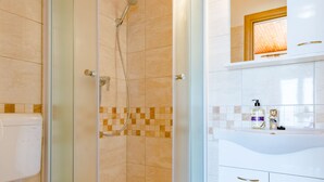 A modern bathroom with a glass-enclosed shower, a white toilet, and a sink with a mirror above it. - Rooms Sani - Double Room with Terrace and Sea View (S3) (Brela)