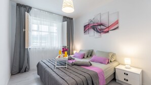 Een moderne slaapkamer met een bed, nachtkastje en kunst aan de muur.