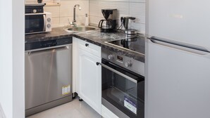 A modern kitchen with stainless steel appliances, white cabinetry, and a window with a view. - Apartment Rea Zaton - Two-Bedroom Apartment (Zaton)
