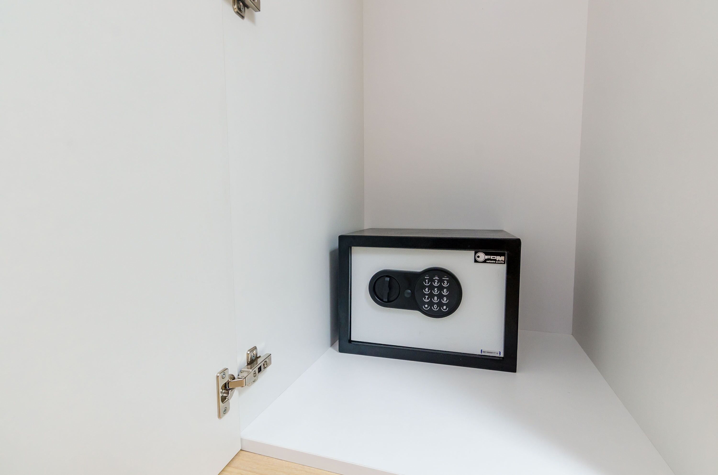 A secure storage unit with a combination lock in a corner of a room.