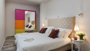 A neatly made bed with white linens and brown pillows, a bedside lamp, and a small table with a vase of flowers. - Apartments Subrenum - Superior Studio Apartment with Small Terrace (S4) (Mlini)