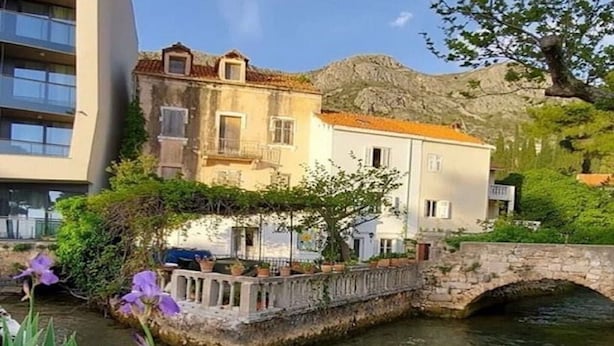 A stone bridge over a calm water body, with buildings on either side, one with a balcony and the other with a flat roof. - Apartments Subrenum - Superior Studio Apartment with Small Terrace (S4) (Mlini)