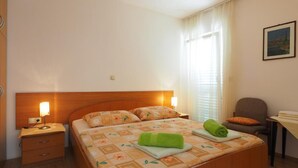 Una camera da letto ordinata con un letto, un comodino e una sedia.