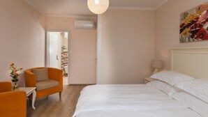 A bedroom with a bed, a chair, a table, a lamp, and a painting on the wall. - Superior Double Room with Balcony and Sea View (Soba 3) (Orasac)