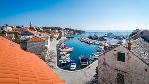 A coastal town with a marina, stone buildings, and a clear blue sky. - Rooms Miron - Deluxe Double Room with Balcony and Sea View (Sumartin)