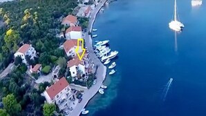 Vista aérea de una zona costera con edificios, un puerto deportivo y barcos.
